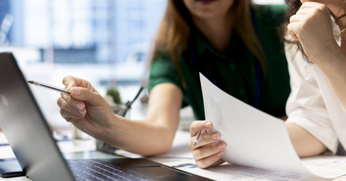 coworkers-using-laptop-to-check-on-work-permit